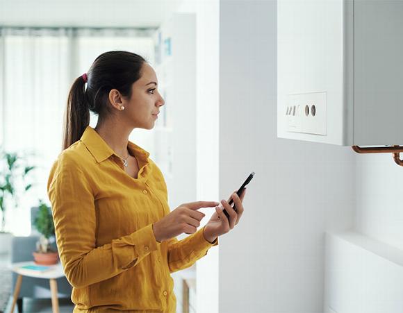 Lady looking at boiler about to call plumber