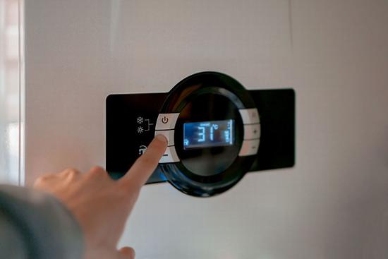 person adjusting settings on boiler controls
